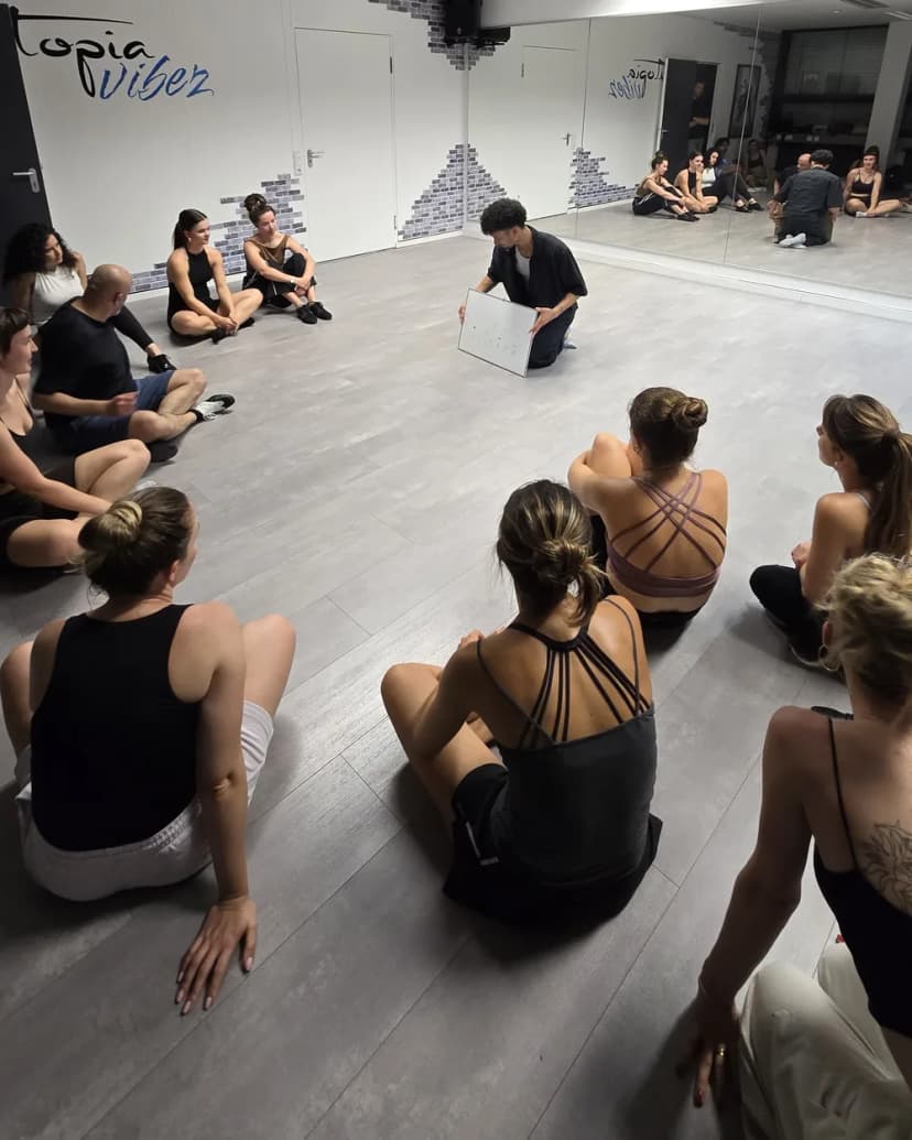 The class sitting in a circle around the instructor at Utopia Vibez